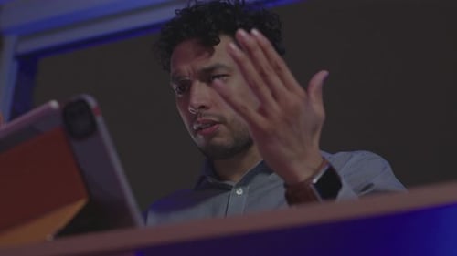 Worried Man Looking at Tablet in Dark Room