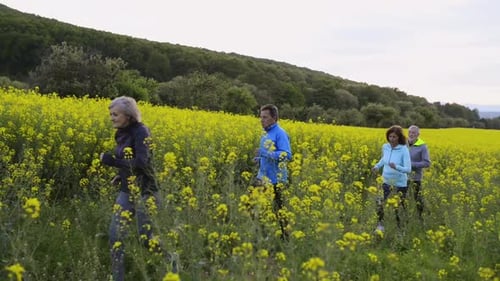 Group of Seniors Running Outside in Canola Field