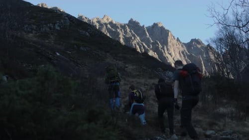 Slow motion shot of hiker group trekking on rocky path in Norwegian mountains during sunny day