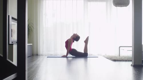 Woman Practices Yoga in Brightly Lit Home
