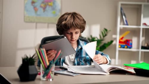 in the Children's Room a Schoolboy in a White Sweater and a Blue Checkered Shirt at a Desk Does