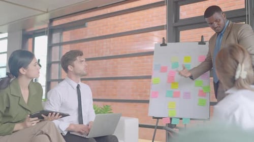 African American business man stand to present team project with co-worker in meeting area