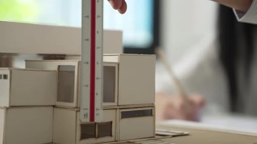 Skilled professional engineer hand using ruler measure house model. Immaculate.