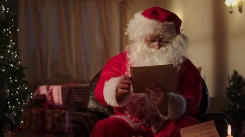Santa Claus Reads Letters by Christmas Tree