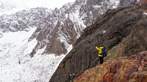 Hiker Celebrating Reaching the Summit of a Snowy Mountain