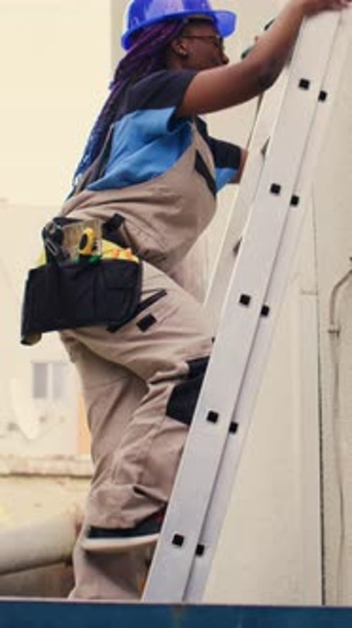 Construction Worker Climbing Ladder Outdoors During Daytime
