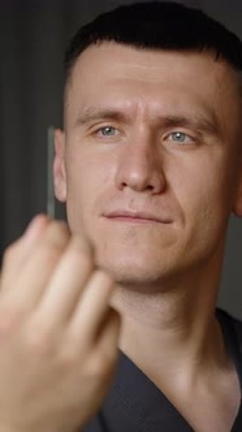 Gros plan d'un acupuncteur focalisé préparant une fine aiguille stérile positionnant soigneusement le