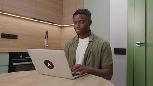 Young Adult Working on Laptop in Modern Apartment