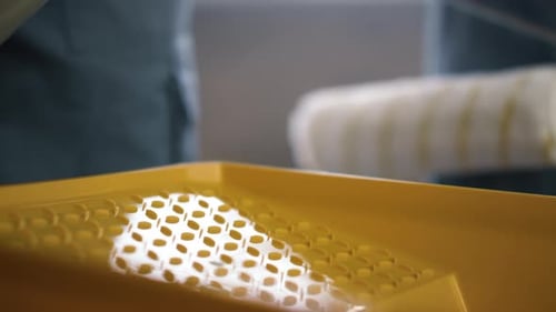 Paint Being Poured into Yellow Paint Tray