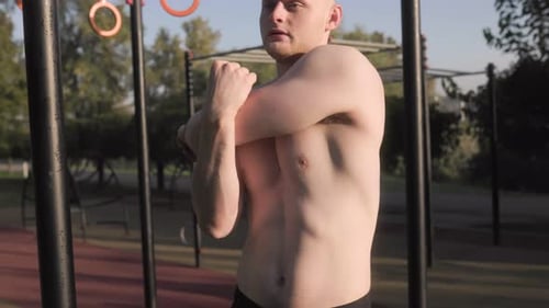 Young Man with Naked Torso Doing Intense Outdoor Strength Training