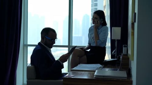 Business people working in hotel room on devices