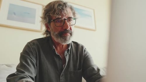 Man Working on Laptop at Home During Daytime