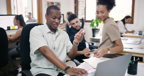 4k video footage of a young businessman and businesswoman using a laptop together in a modern office