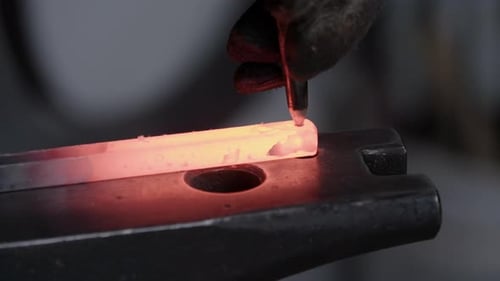 Smith Piercing Hot Metal Bar on Anvil