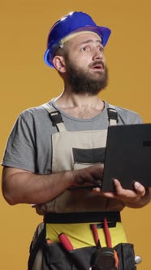 Vertical Video Portrait of Handyman Using Laptop to Find Construction Inspiration