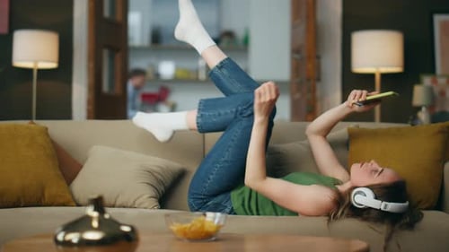 Woman Relaxing on Couch Listening to Music