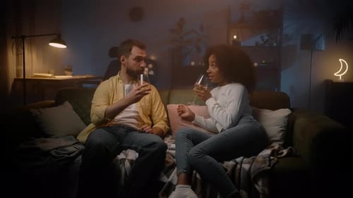 Young Spouses Clinking Wine Glasses at Evening Sofa