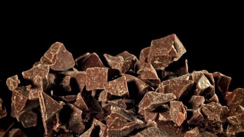 Chunks of chocolate flying on a black background