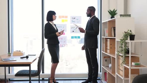 Business Professionals Discussing Charts in Bright Office
