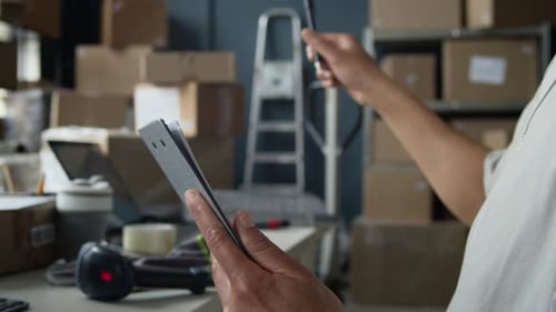 Warehouse Worker Checking Stock and Writing on Clipboard