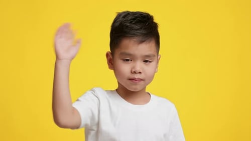 Child Waving with a Bright Yellow Background in a Charming Setting