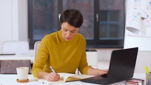 Business Technology and People Concept - Businesswoman with Laptop Computer Writing To