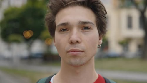 Nahaufnahme des jungen kaukasischen gutaussehenden Mannes, der draußen steht, ernsthafter Mann allein in