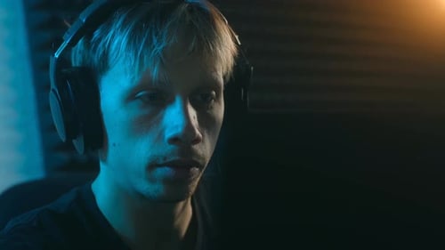Focused Young Man Wearing Headphones Playing Video Games