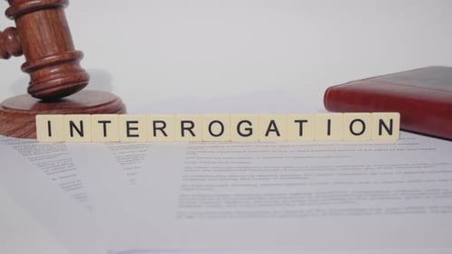 Interrogation Gavel and Law Book on White Surface