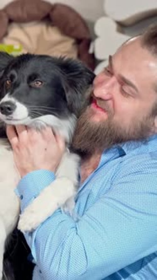 Man Holds Happy Dog Indoors Portrait Orientation