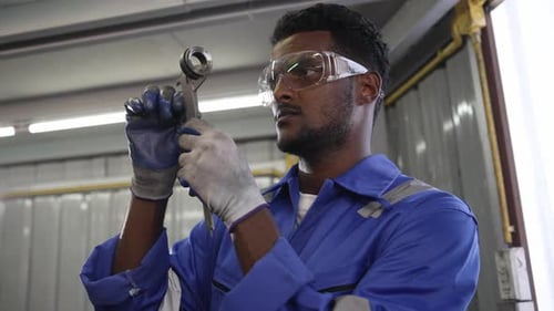 African mechanic worker inspecting on equipment parts for repairing on lathe machine
