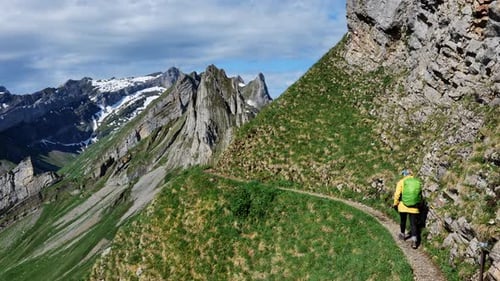 A Hiker Explores a Scenic Mountain Trail Surrounded By Majestic Peaks Enjoying Nature