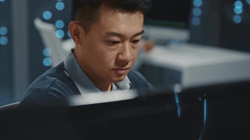 Asian Young Handsome Smart IT Specialist Working on Computer Desktop in Office Data Center Database