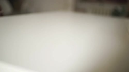 Ball of White Yarn Being Unwound on Table