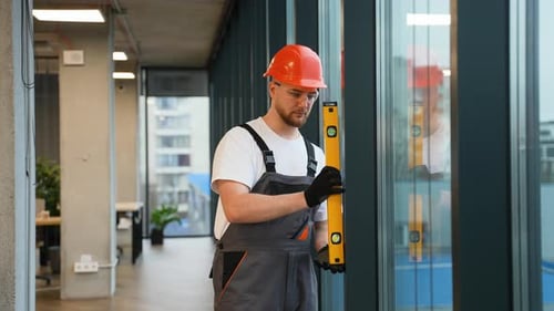 Construction Worker Using Spirit Level Installing Office Window
