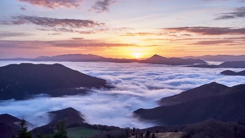 Ondes de nuages dans une vallée de montagne Inversion des nuages dans un paysage montagneux au lever du soleil