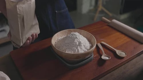 Measuring Flour into Bowl with Rolling Pin and Spoons
