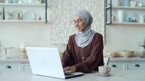 Woman Working on Laptop in Bright Kitchen
