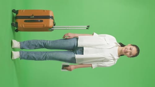 Full Body Of Asian Female Traveler With Luggage Holding Passport And Smiling In The Green Screen