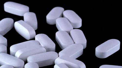 Medikamententabletten auf isoliertem schwarzem Hintergrund. Nahaufnahme, Kamerabewegung, Drogen und Tablets
.