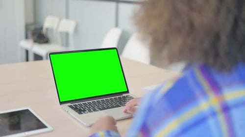 Young African Woman Using Laptop with Green Screen