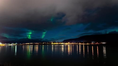 Cloudy Night Sky Timelapse Of Aurora Borealis (Northern Lights) By The Lake In Iceland - wide shot