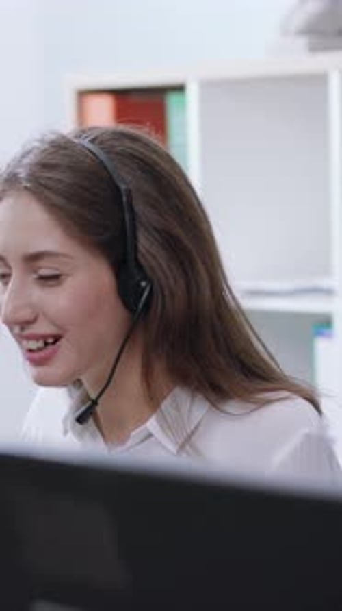 A Professional Woman Engaged in Work Duties at a Call Center Wearing a Headset for Communication