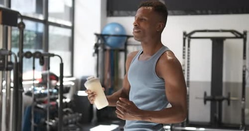 African Man Drinking a Protein Shake in a Gym