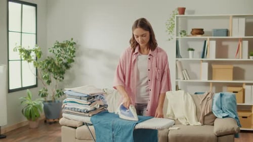 Woman Irons Clothes on Ironing Board