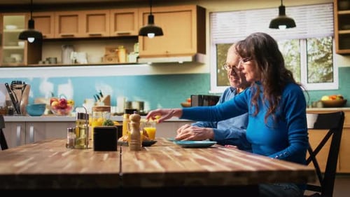 Senior Couple Having Breakfast Together at Kitchen Table