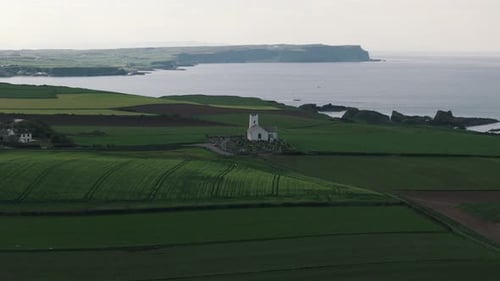 Slow Descending Approach to Coastal Church with Cliffs and Ocean