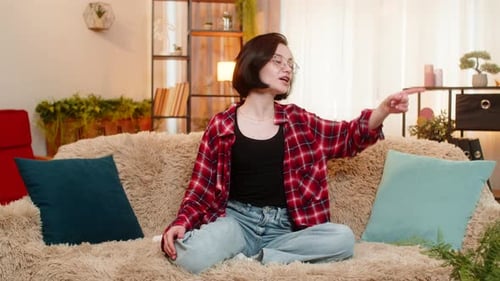 Jeune femme répétant un monologue à la maison, faisant des gestes avec émotion et engagement théâtral total