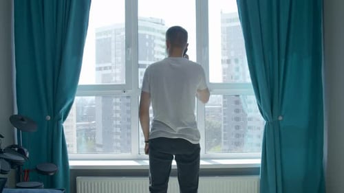 Man Talking on Phone in Urban Apartment
