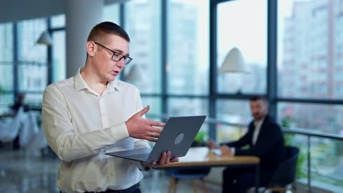 Young Man with Laptop in Modern Office